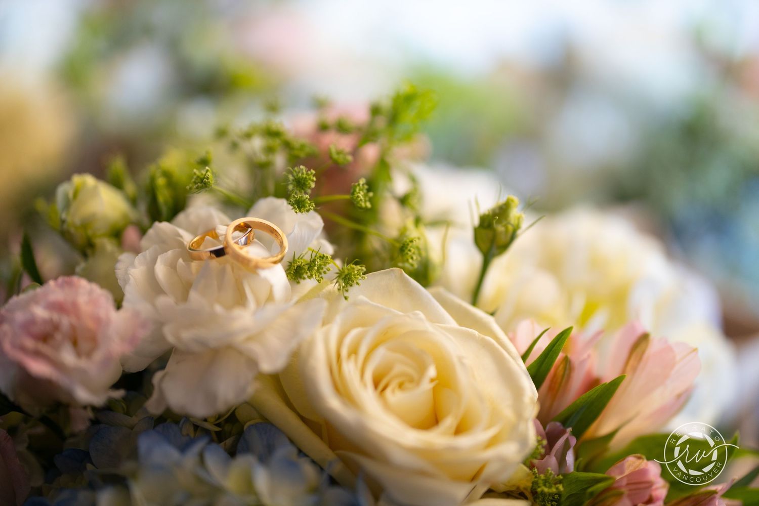 Delicate cream and pink roses in a wedding bouquet with soft focus bokeh background.