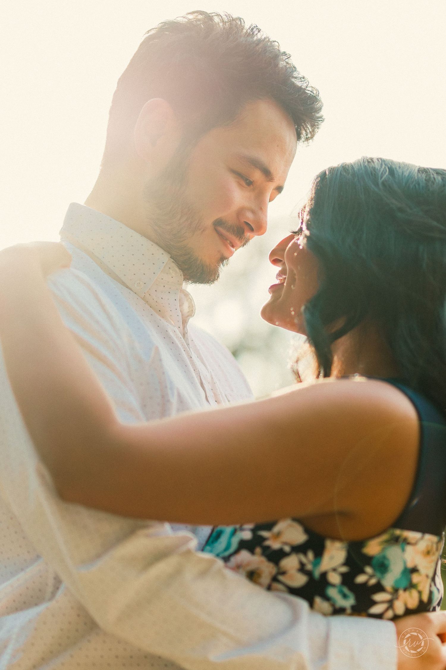 A romantic couple shares an intimate moment in warm sunset lighting.