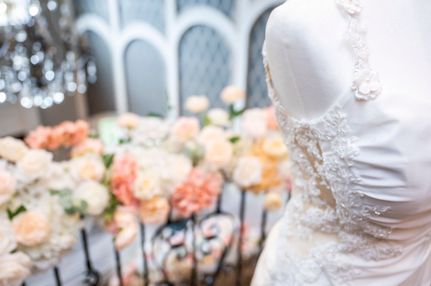 A wedding reception table decorated with elegant pink and white floral arrangements and crystal glassware.