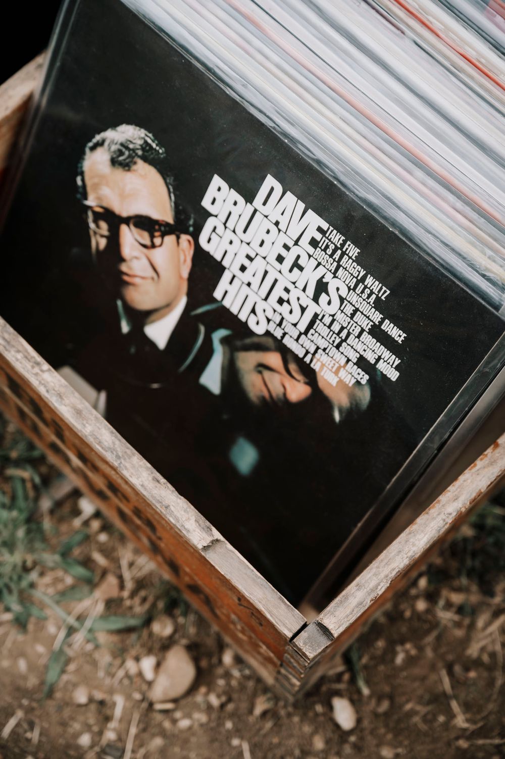 Primo piano di dischi in vinile in casse di legno durante un evento all'aperto.