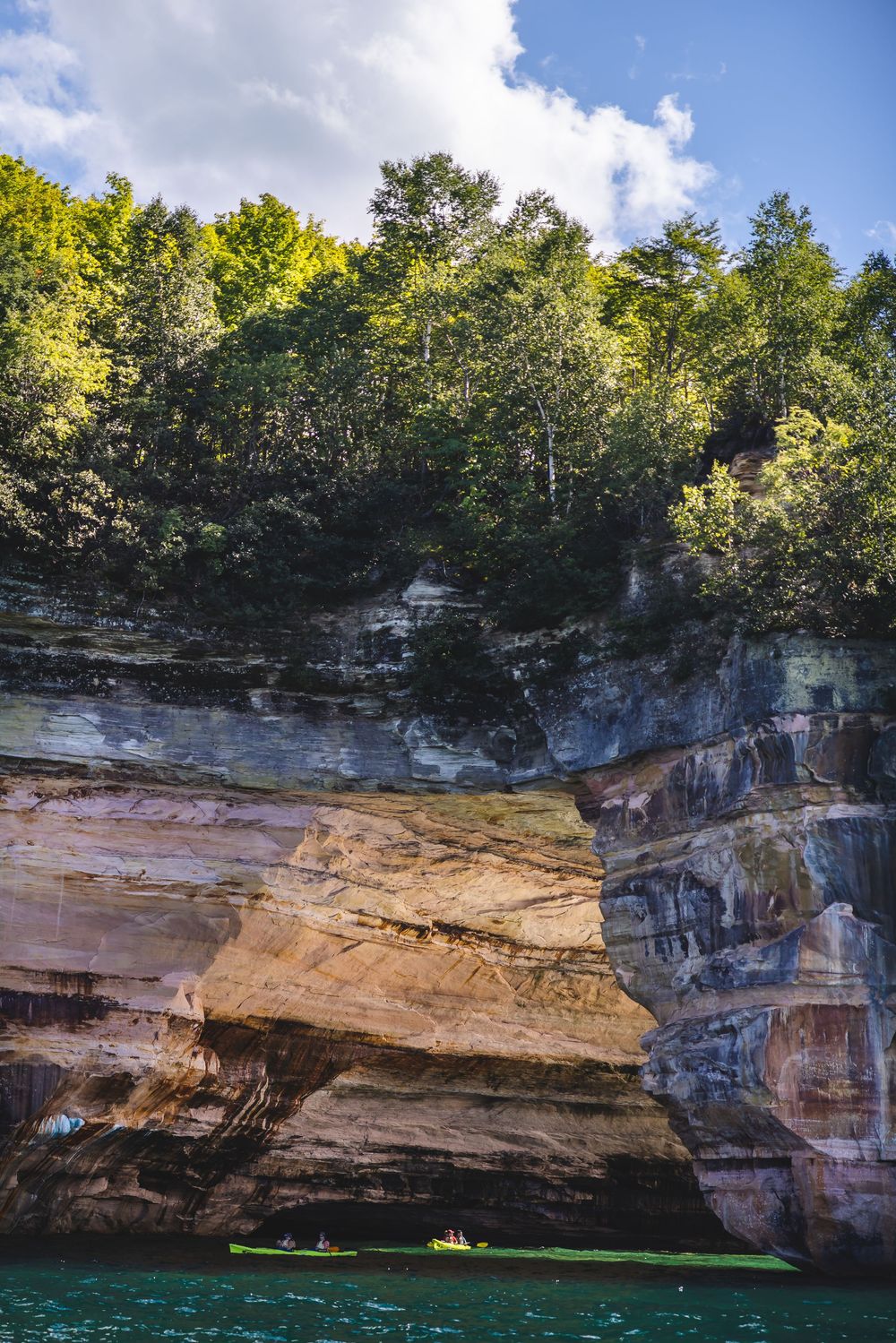 Dramatic limestone cliffs and rock formations tower over turquoise waters at Pictured Rocks National Lakeshore in Michigan.
