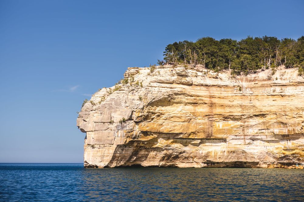 Scenic aerial view of limestone cliffs and rock formations along the coastline of Pictured Rocks National Lakeshore.