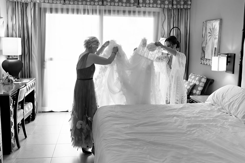 Black and white photo of a wedding dress boutique interior showing multiple gowns on display and fitting areas.