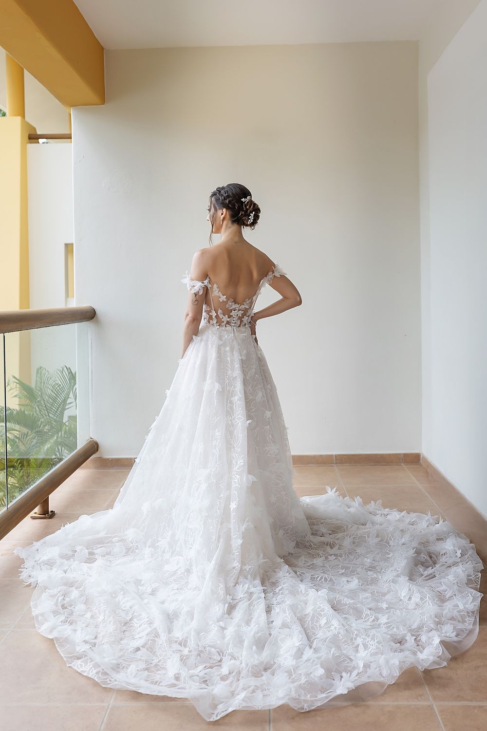 A stunning white wedding gown with intricate floral details and a dramatic cathedral-length train shown from multiple angles.