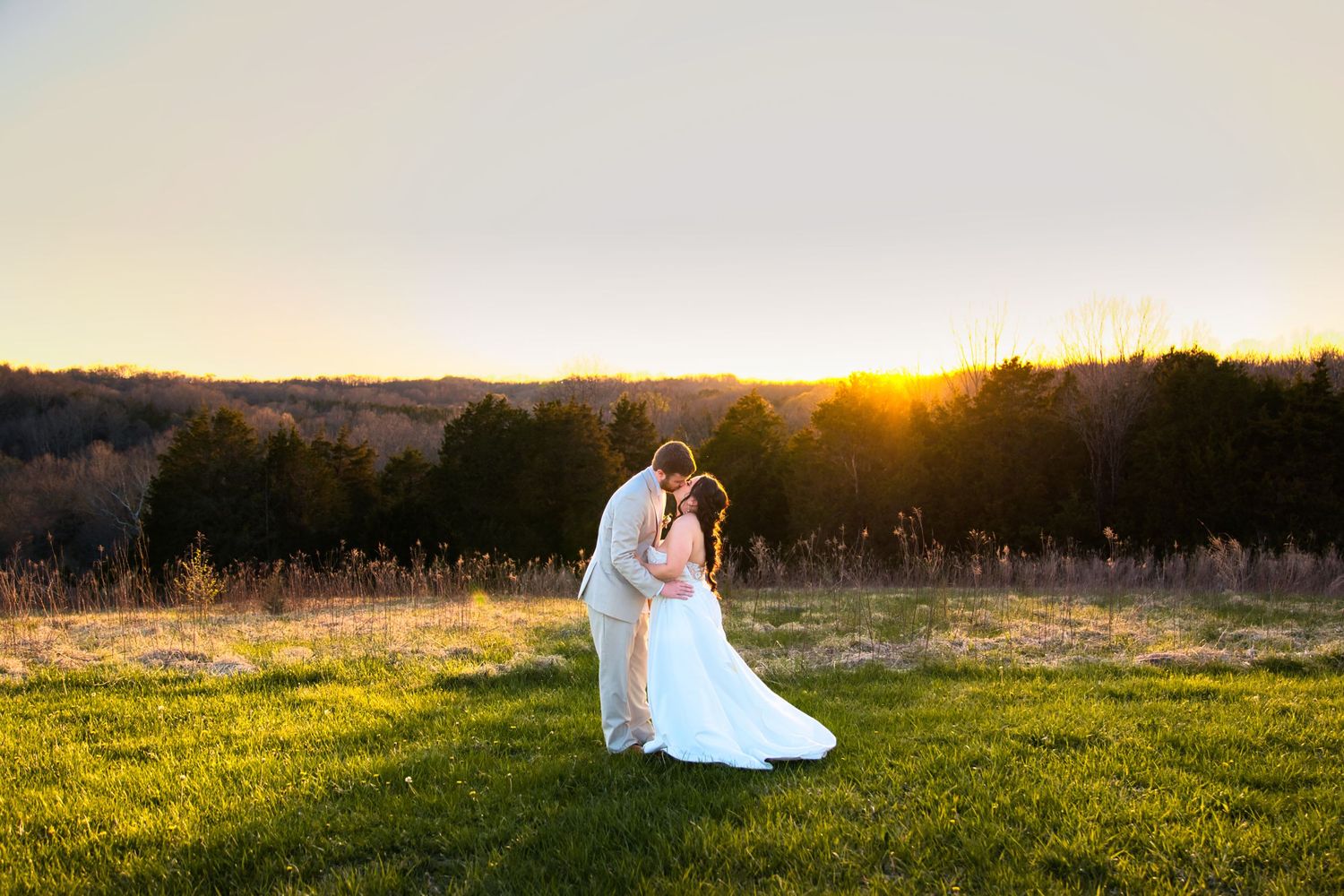 Adrianna and Zack having sunset golden hour portraits in a field kissing at The View Event Center in Williamstown Kentucky