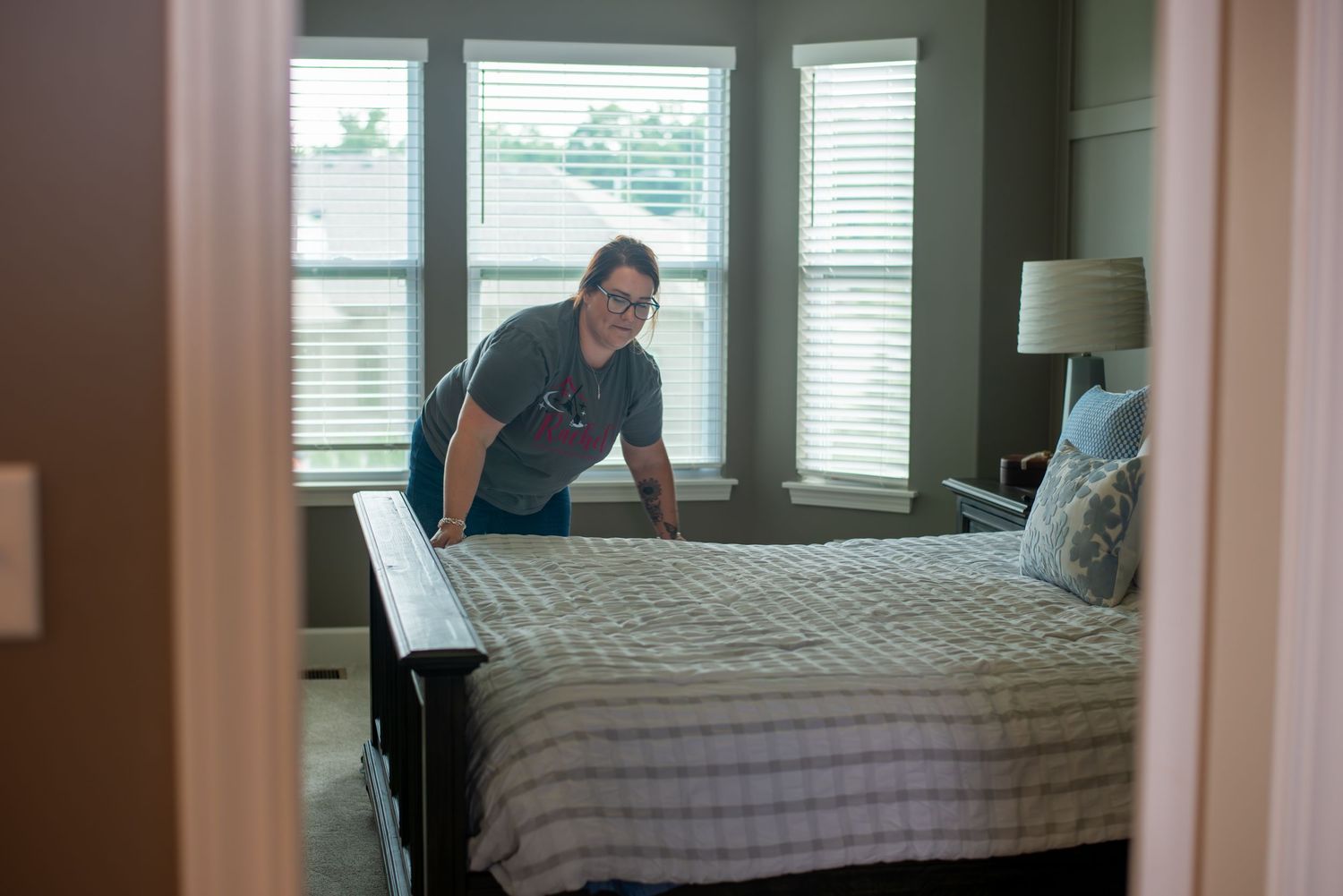 Interior bedroom scene with natural light streaming through venetian blinds.