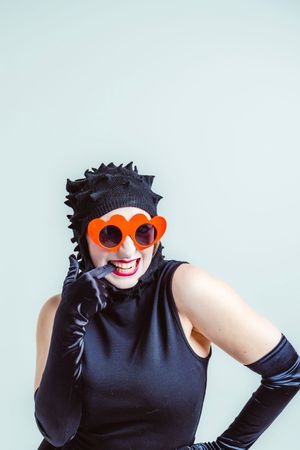 Person in black sleeveless top wearing orange sunglasses and posing playfully in a photo collage.