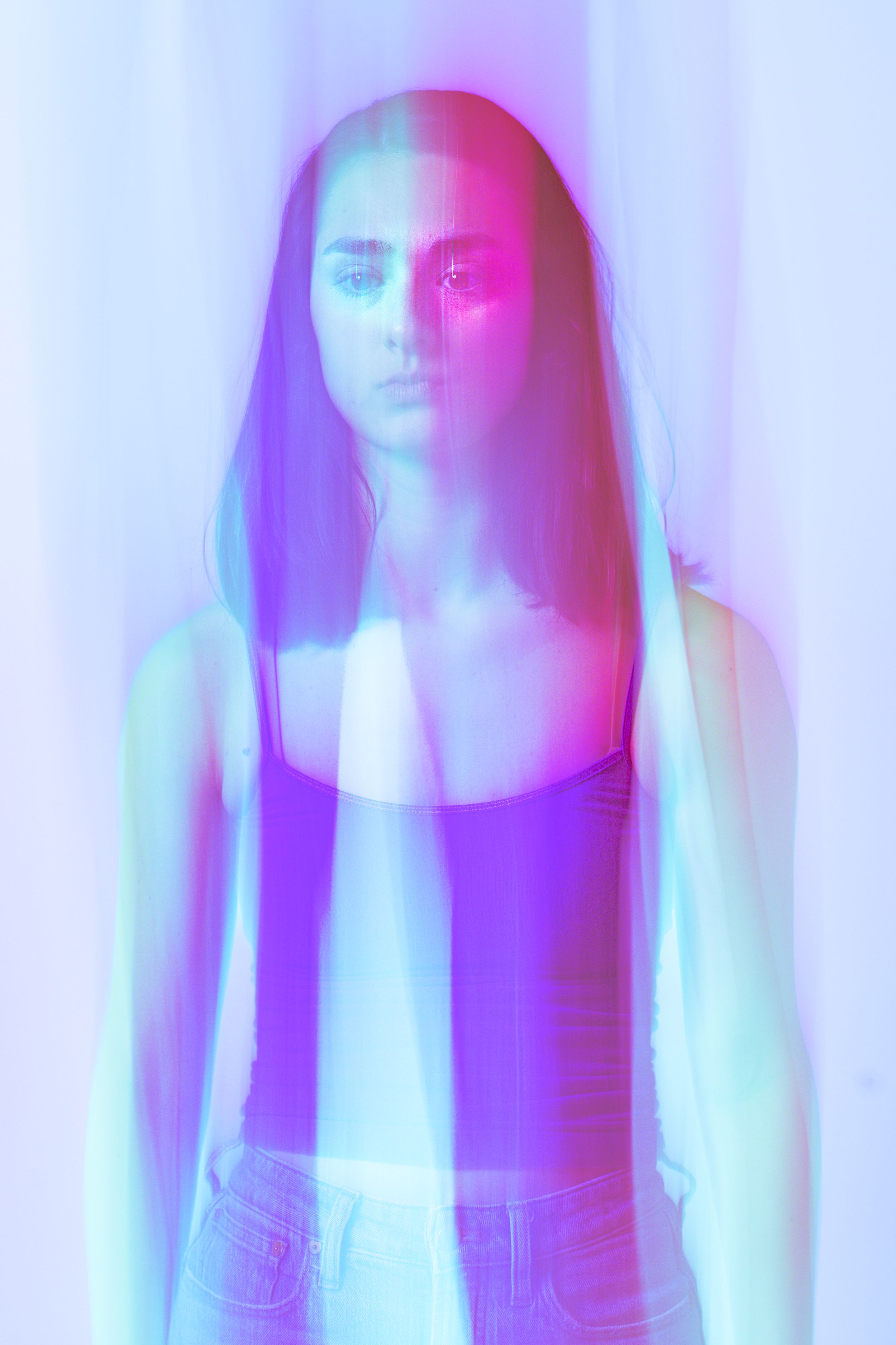 Multiple overlapping portraits with ethereal blue and pink lighting create a dreamy, ghostly effect in motion.