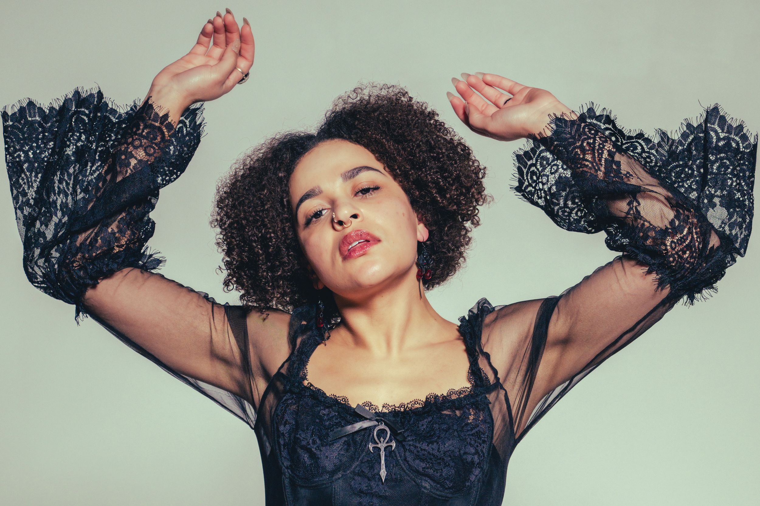 Artistic fashion photo series showing dramatic poses in black lace against a light colored background.