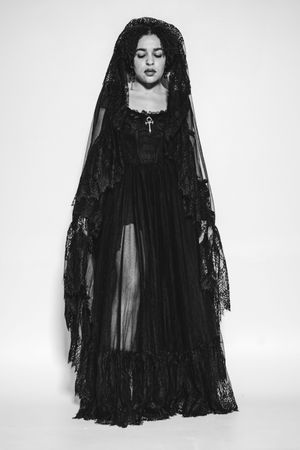 A dramatic fashion photo series showing a model in flowing black gothic lace dress and veil against white background.