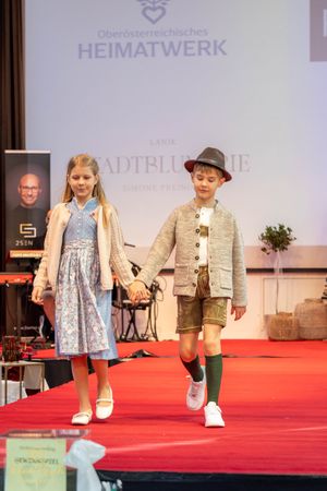 Children's fashion show displaying Austrian folk attire at Heimatwerk cultural event.