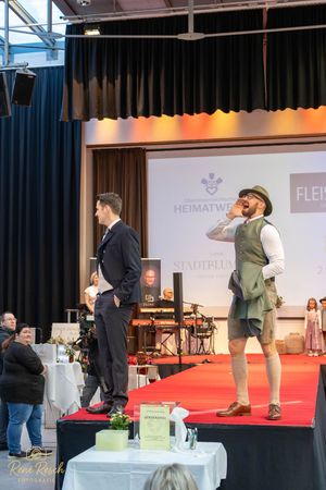 Traditional Bavarian fashion show with models displaying authentic folk costumes on stage.
