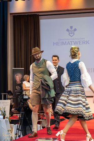 Models showcase traditional Bavarian and Austrian folk costumes during fashion event.