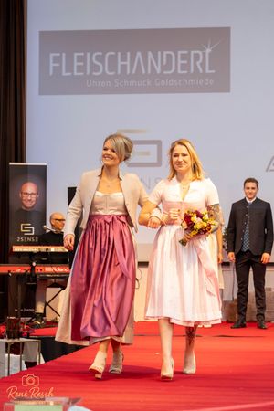 Models present traditional Austrian and Bavarian folk dresses during fashion event.