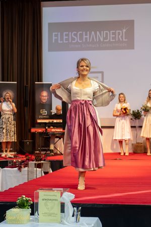 Model poses in a pink and beige dirndl dress during Fleischanderl fashion show.