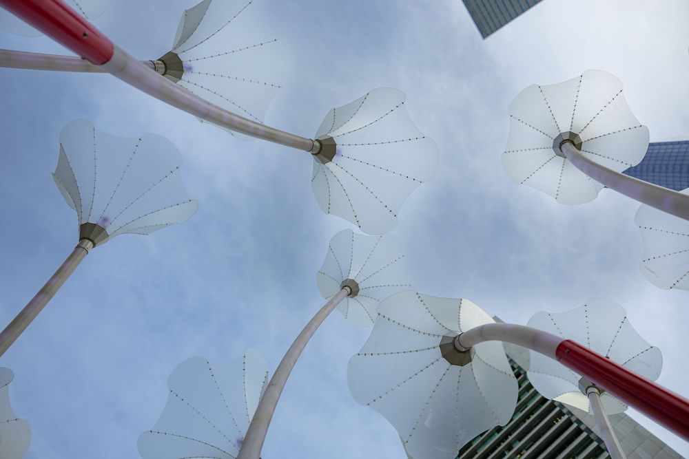 White windmills spin against a cloudy blue sky in Mykonos, Greece.