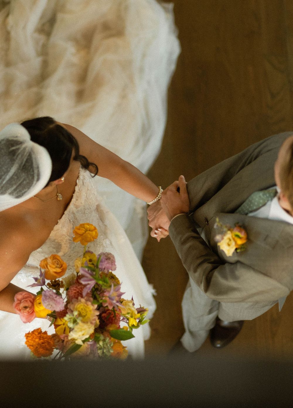 A sequence of wedding photos showing a couple's feet with colorful flowers and white dress details.