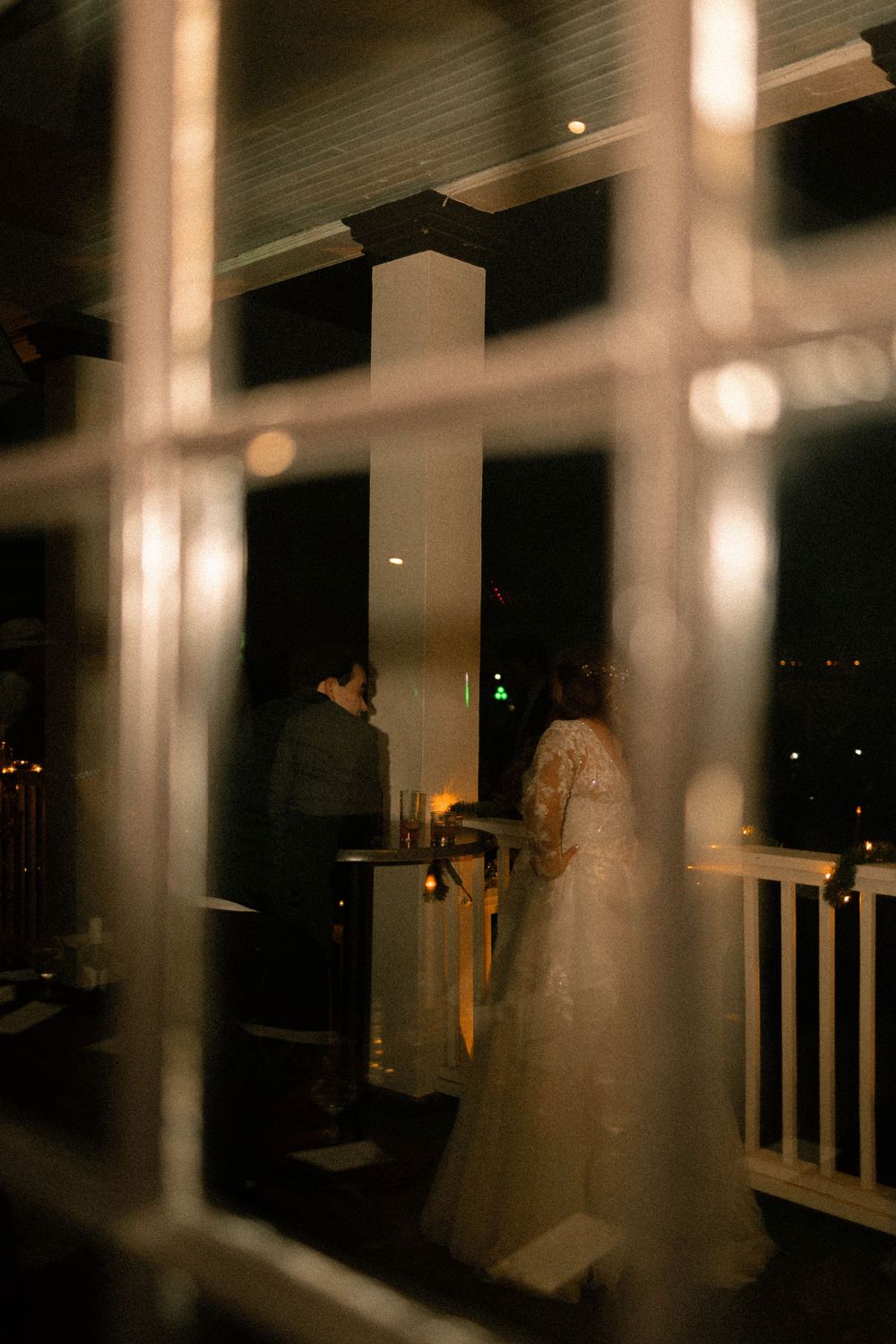 A sequence of romantic nighttime photos showing silhouettes of a couple embracing on a dimly lit porch with glowing lights.