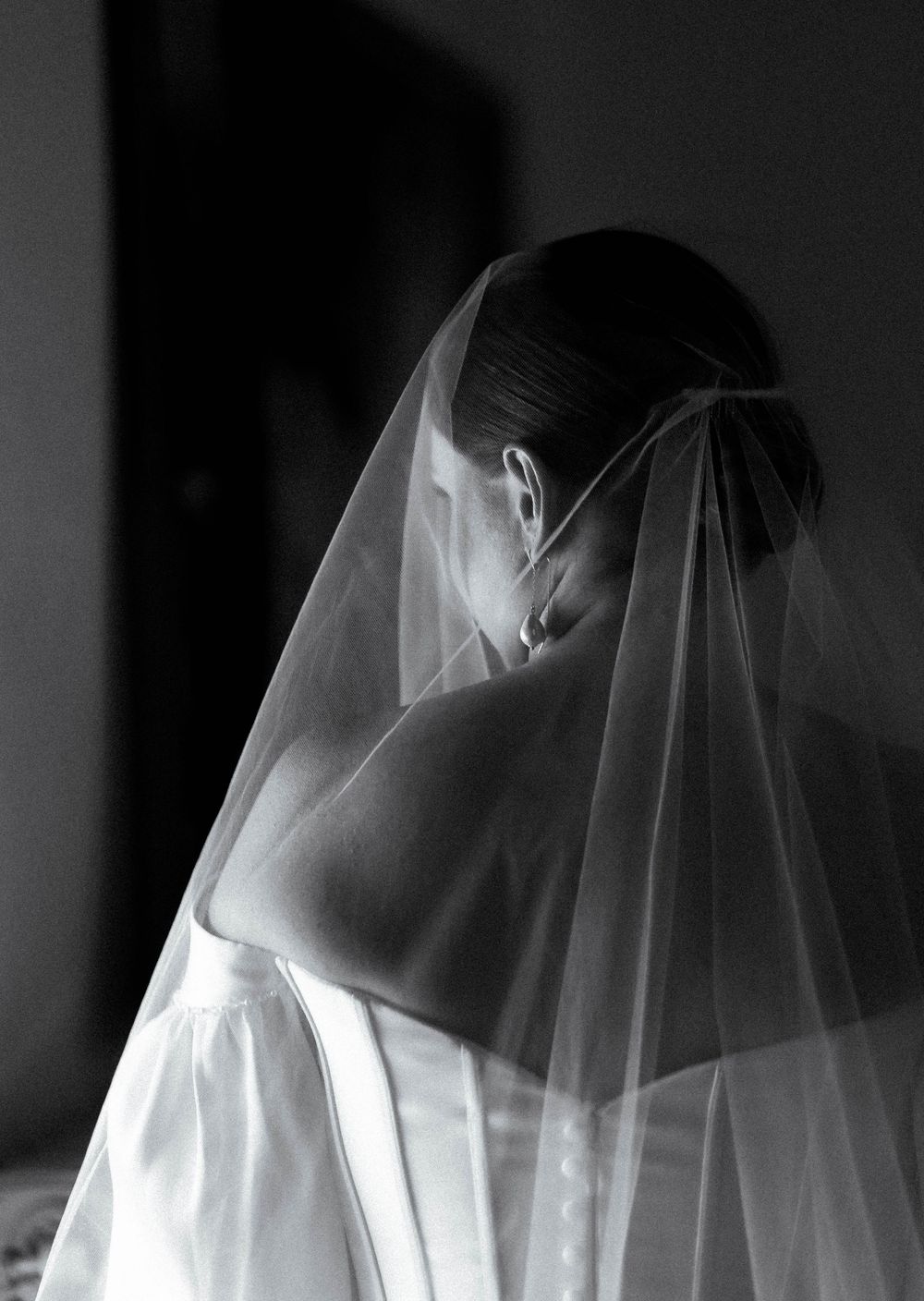 Artistic black and white photo series showing delicate movement of a sheer white veil against a dark background.