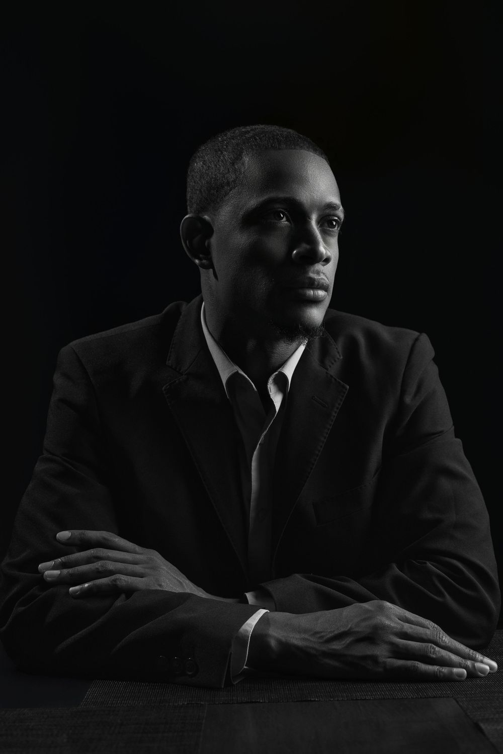 Artistic black and white portraits showing dramatic lighting on someone in formal attire.
