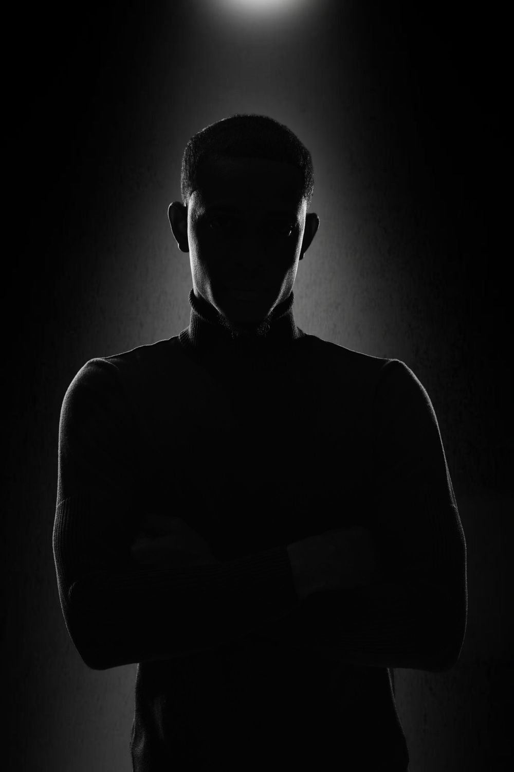 Dramatic silhouette portraits showing a backlit figure against a stark black background.
