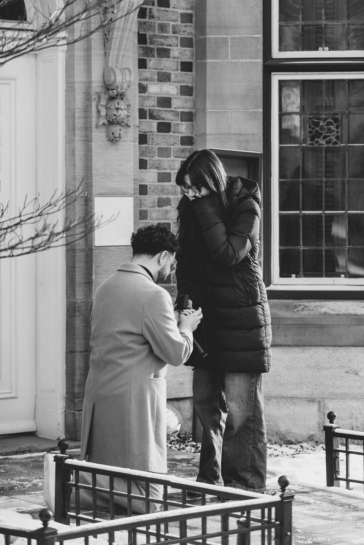 A sequence of four black and white photos showing people interacting at the entrance of a brick building.