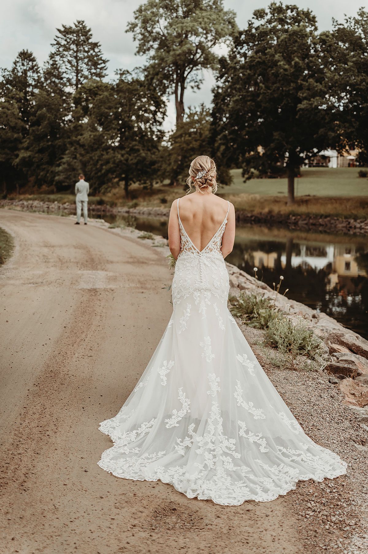 First look vid kanalen Borensberg, en brud går mot sin man i en vacker brudklänning med vintage look, bar rygg och långt släp med broderier.