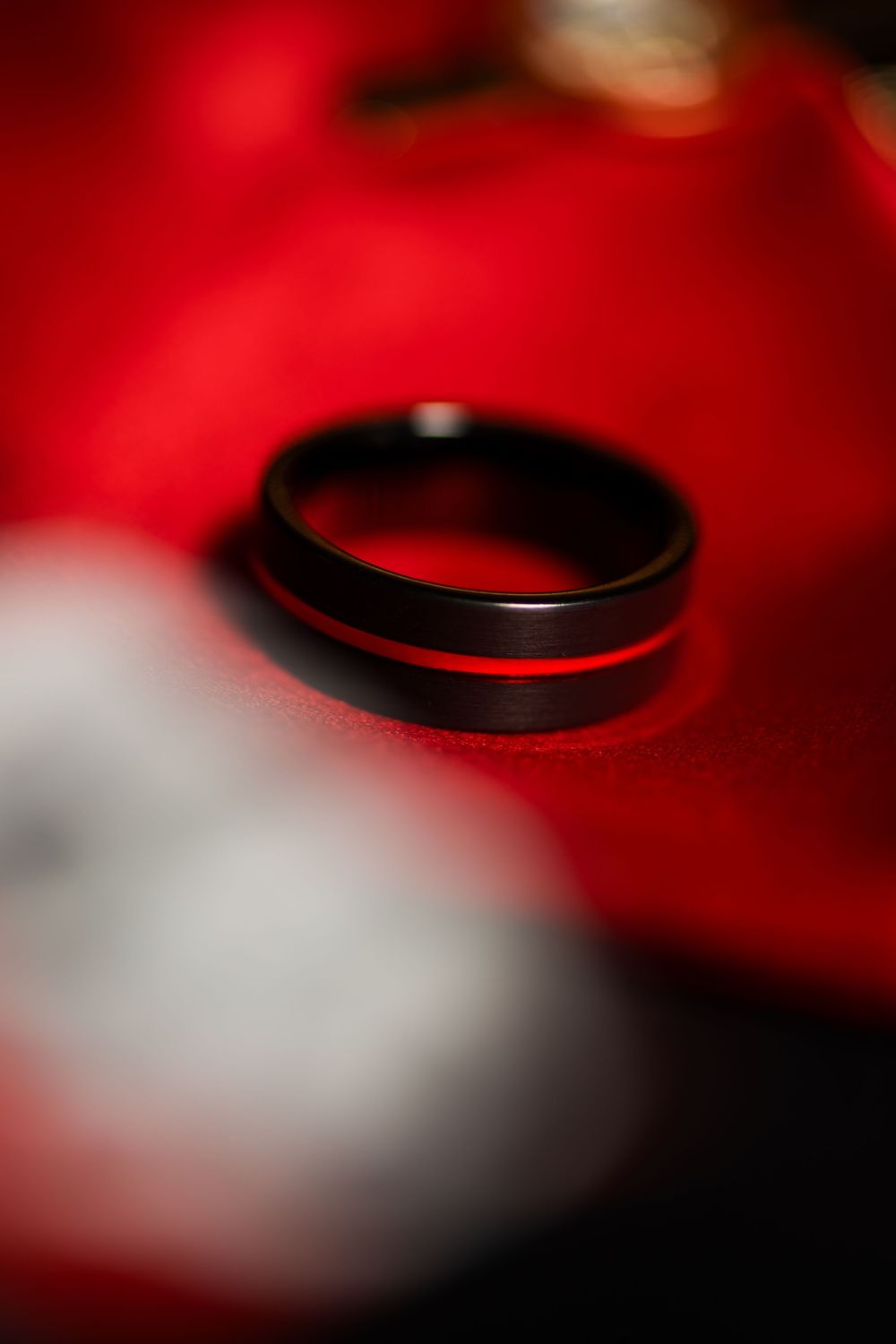 Close-up macro shot of a camera lens filter with red lighting creating an abstract pattern.