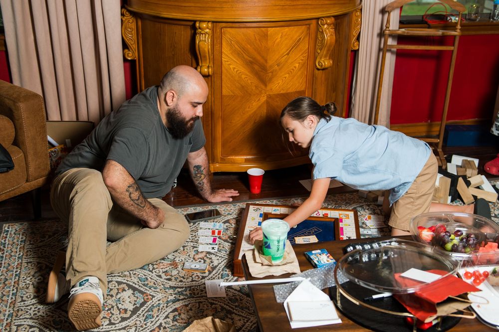 Wedding guests playing board games and socializing at reception table.