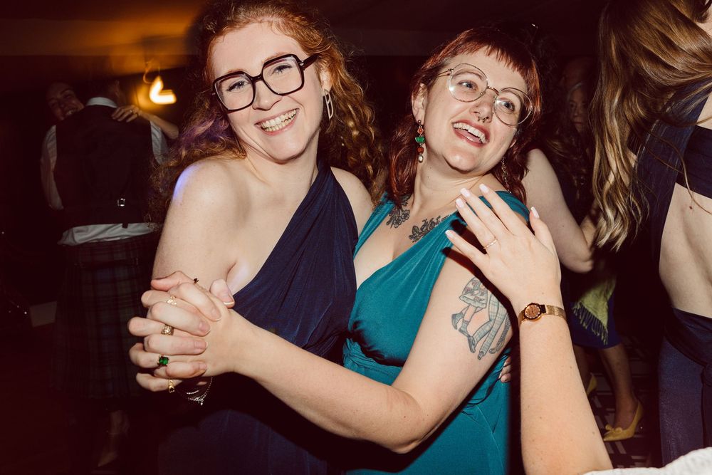 Party guests embrace and dance together during a lively celebration.
