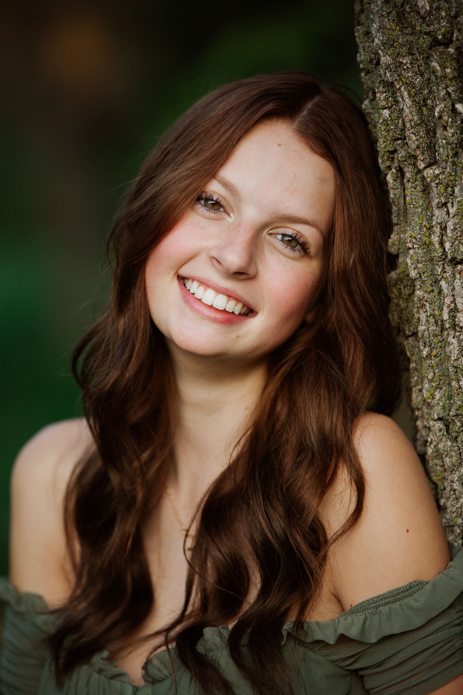 A series of portrait photos showing someone with long brown hair smiling while leaning against a tree trunk outdoors.