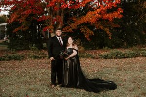 A romantic autumn photoshoot featuring a couple in formal black attire.