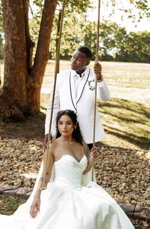 Romantic wedding photoshoot featuring couple on a swing surrounded by autumn leaves.