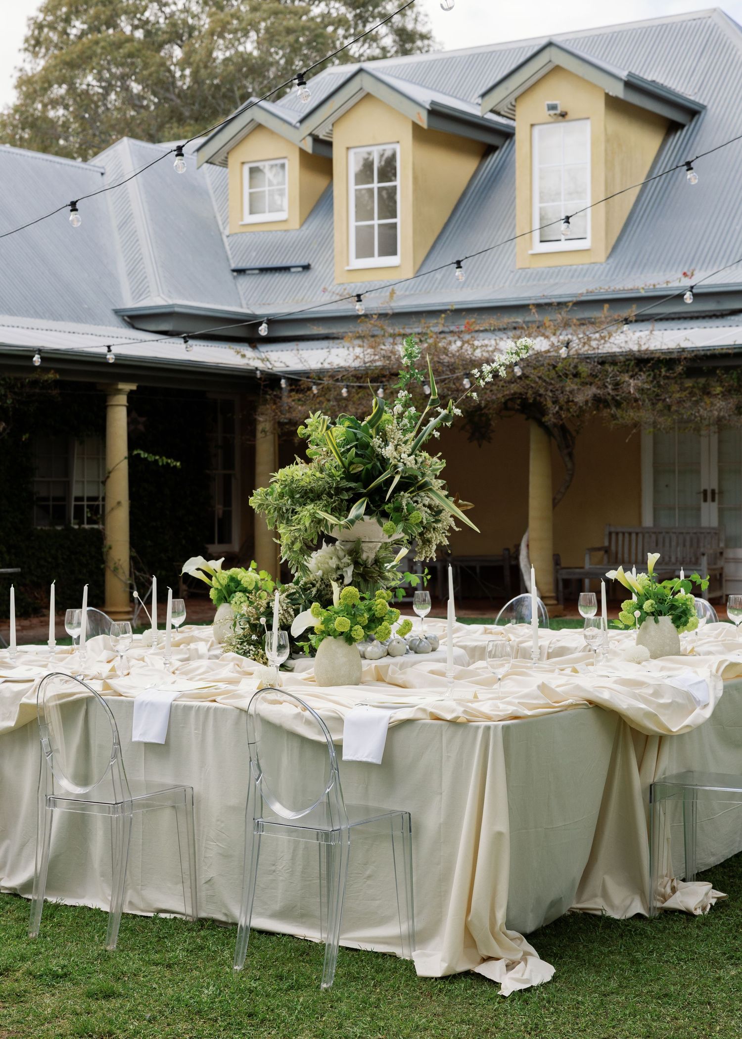 Long tables with white linens and floral centerpieces arranged outdoors for an elegant garden wedding reception at Al Ru Farm in Adelaide.