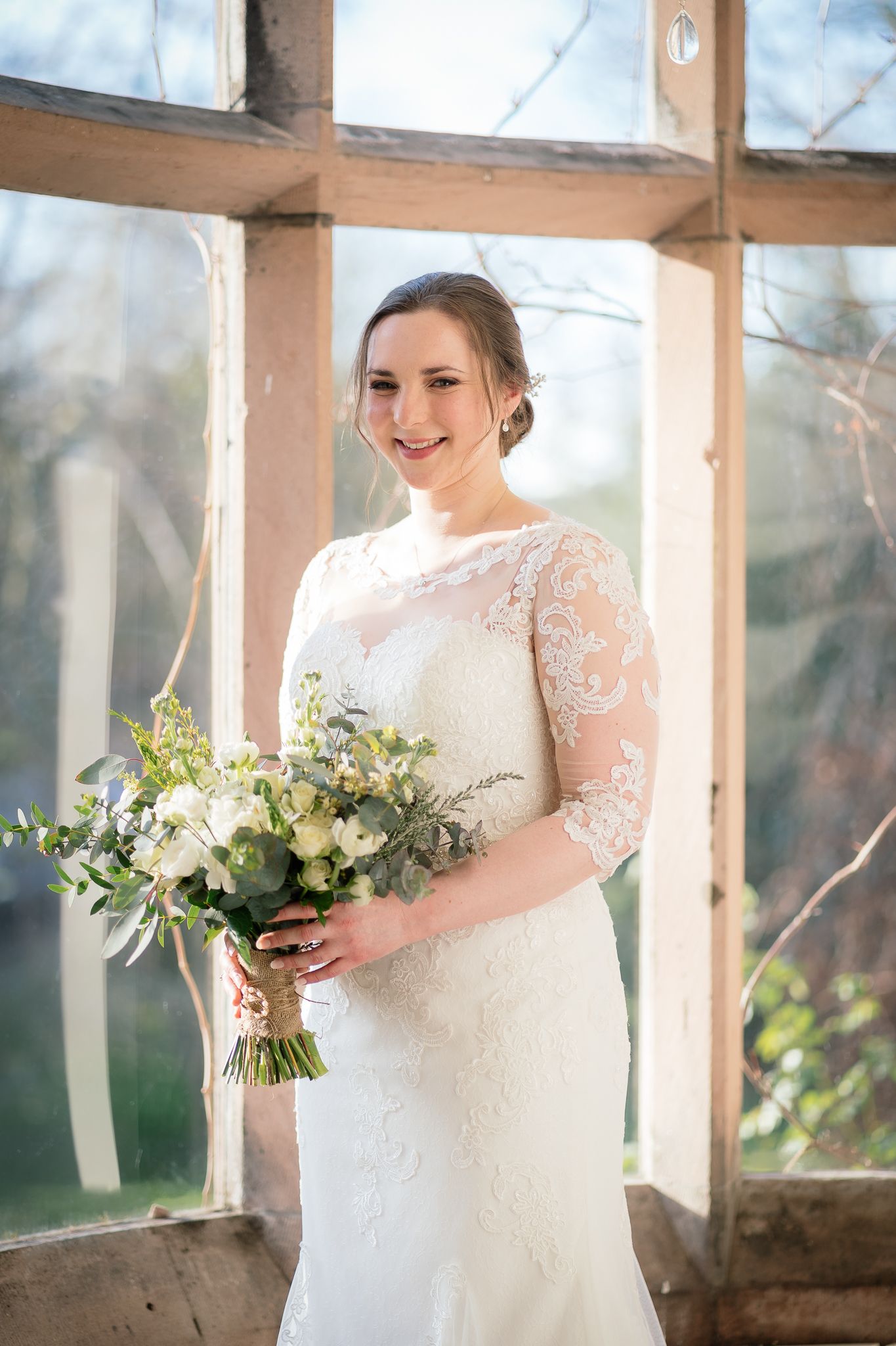 Delicate white bridal bouquet with eucalyptus and flowers photographed in natural window light. Ellingham Hall