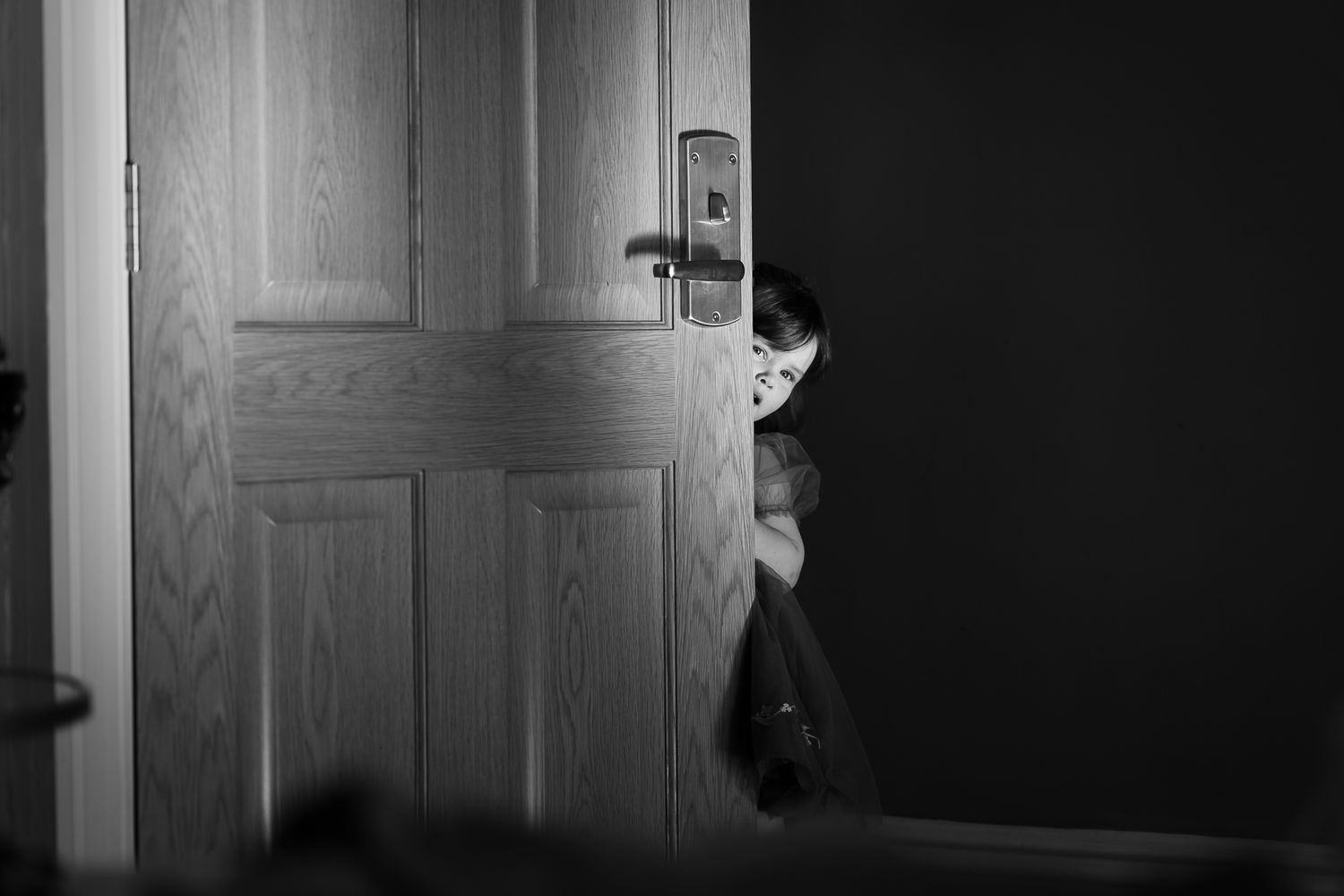 Black and white image showing interior doorway and window light.