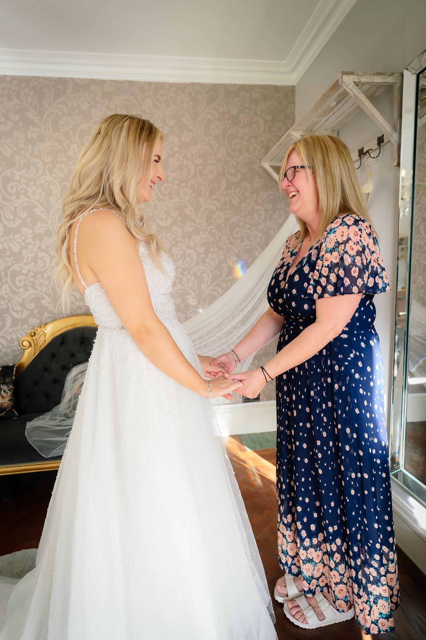 Wedding dress fitting and preparation scene with floral print dress details.