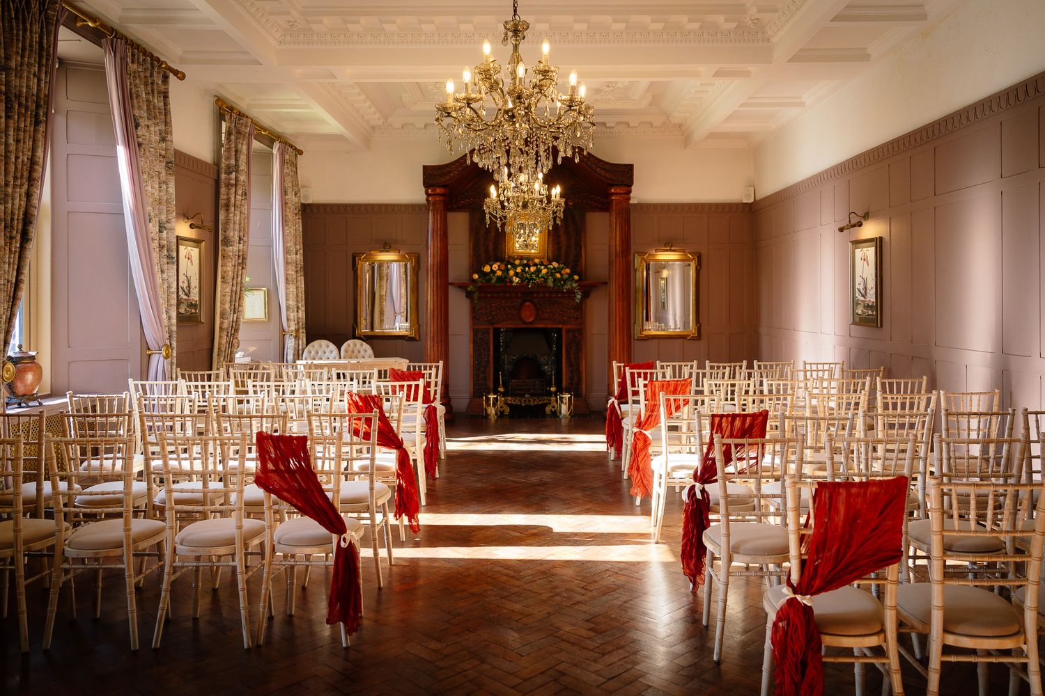 Elegant wedding reception hall with crystal chandeliers and gold chiavari chairs.