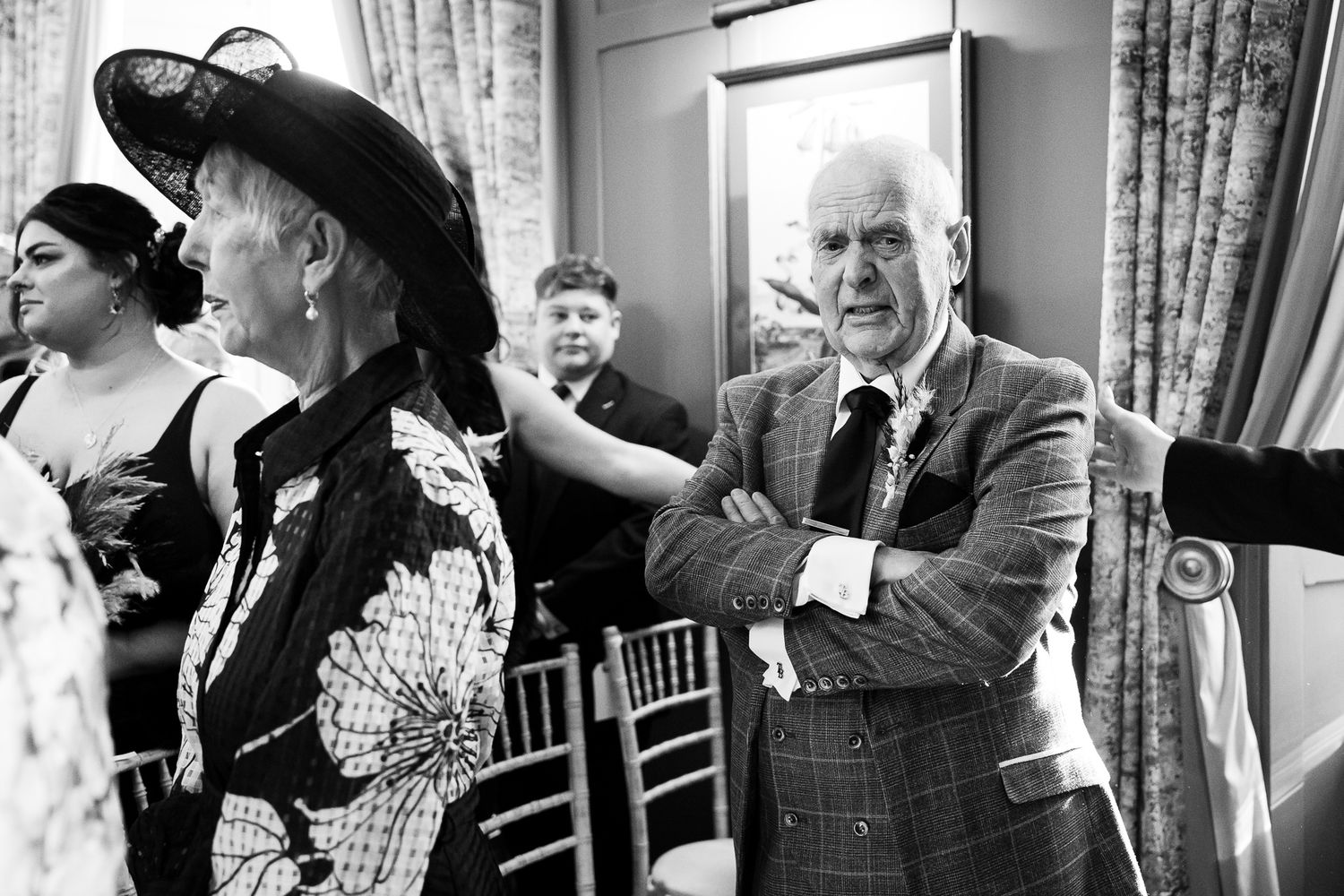 Black and white candid shots of wedding guests laughing and enjoying conversation during reception.