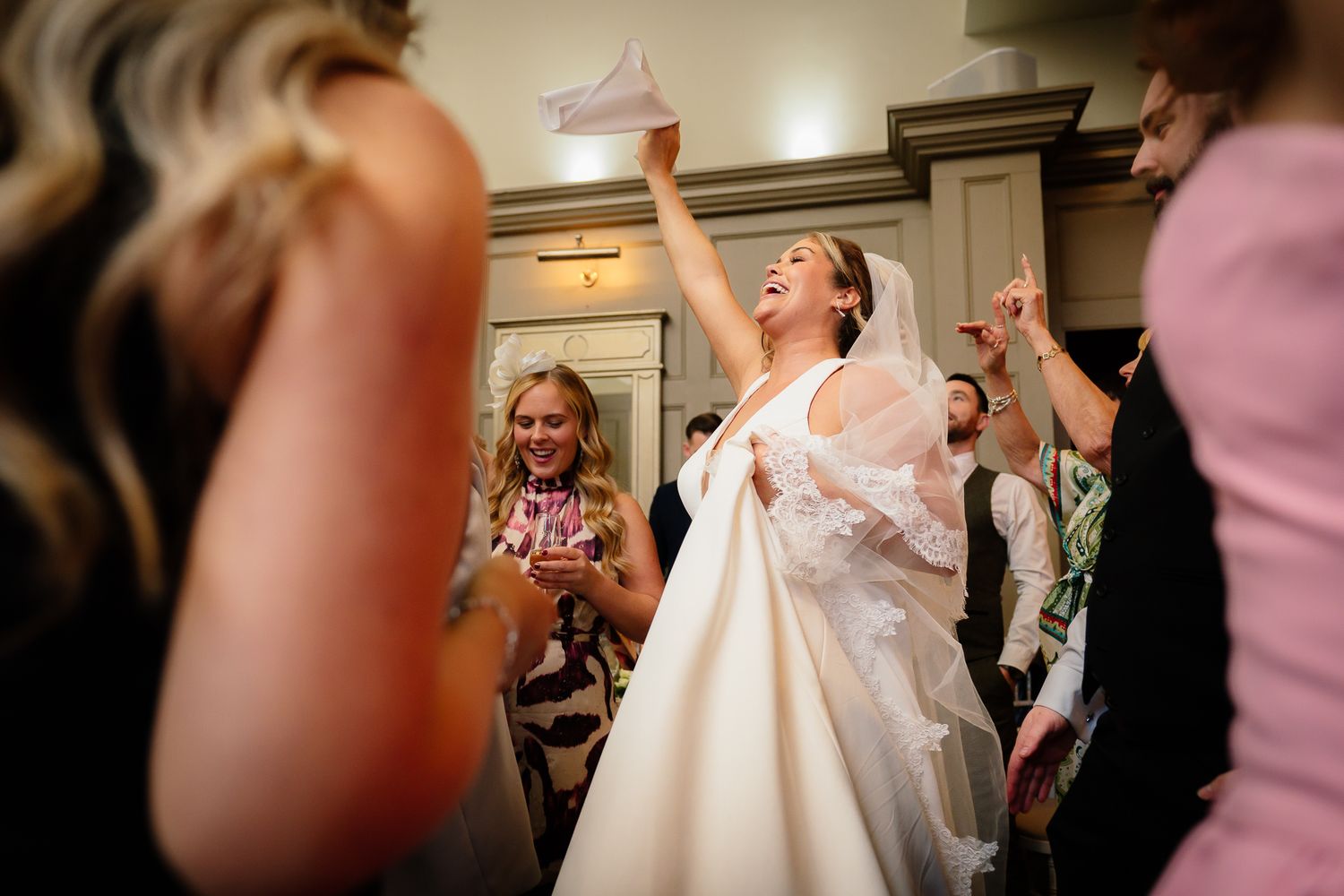 Wedding celebration scene with joyful dancing and celebration indoors.