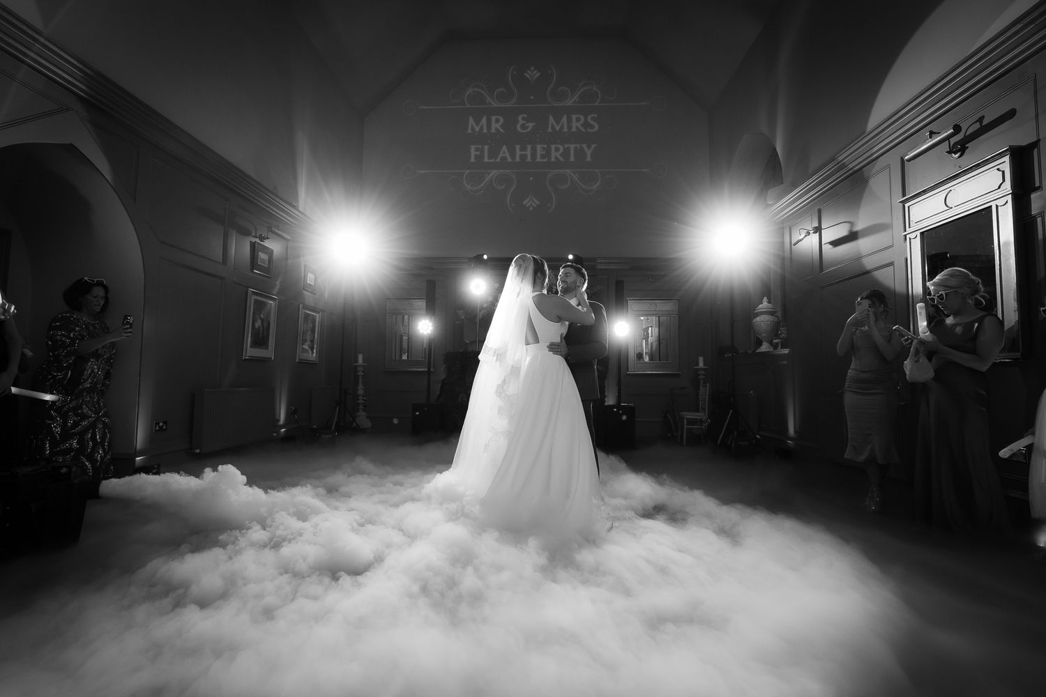 First dance on a misty dance floor creates ethereal atmosphere at wedding reception.