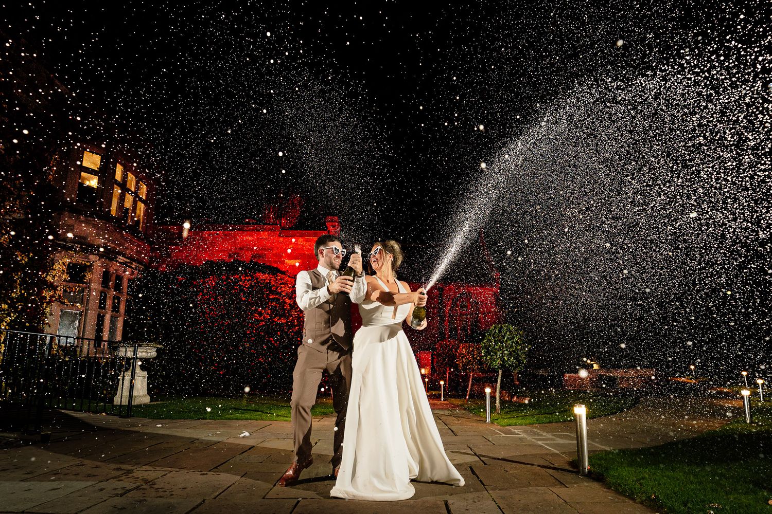 Nighttime wedding celebration with sparklers creating magical light trails in the darkness.