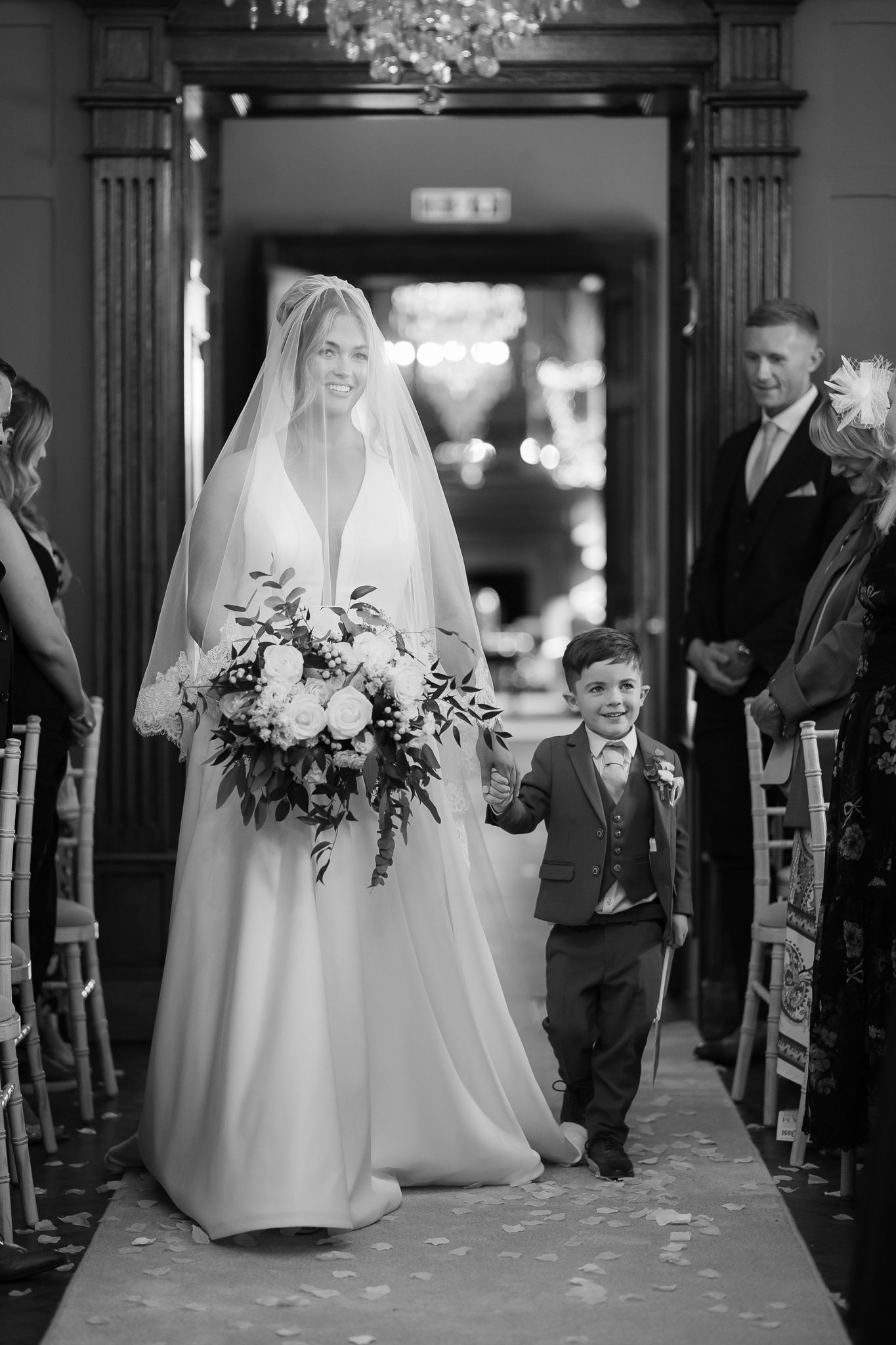 Black and white wedding ceremony photos showing bride walking down church aisle.