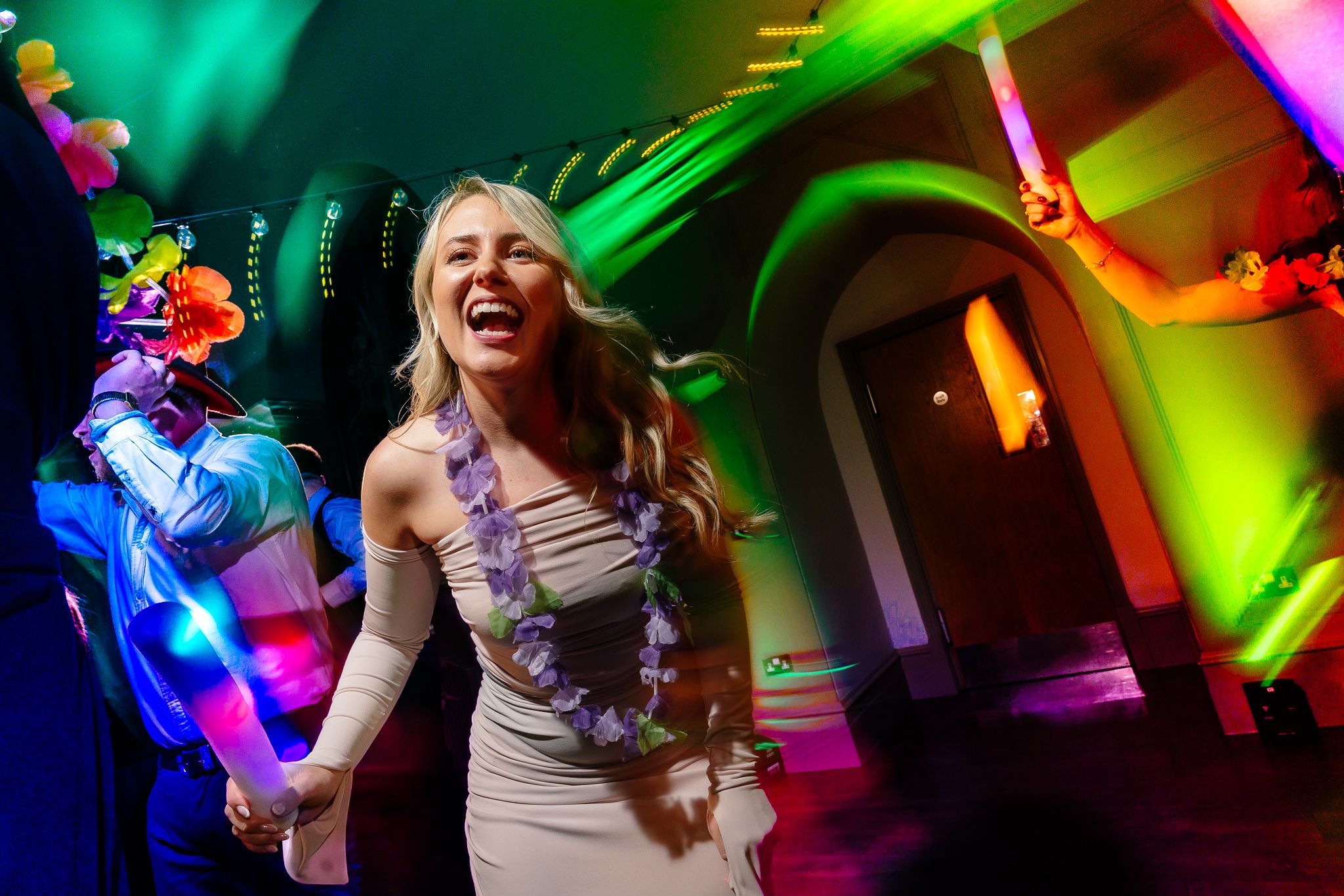 Dance floor filled with colorful lights and party atmosphere in full swing. Ellingham Hall