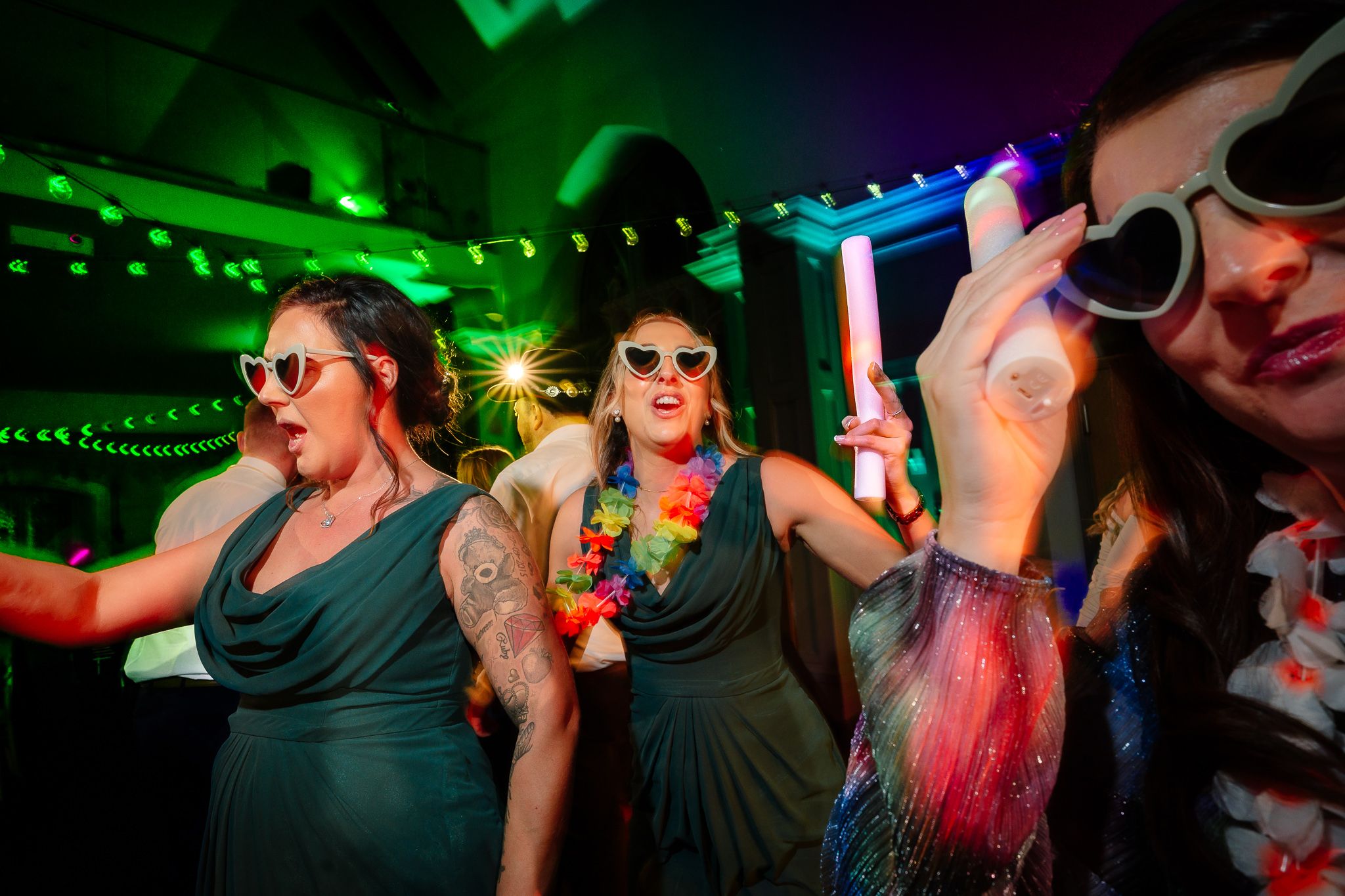Lively nightclub scene with green lighting and dancing partygoers. Ellingham Hall