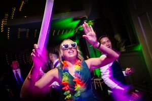 Dance party scene with colorful neon lights and festive decorations at a wedding celebration. Ellingham Hall
