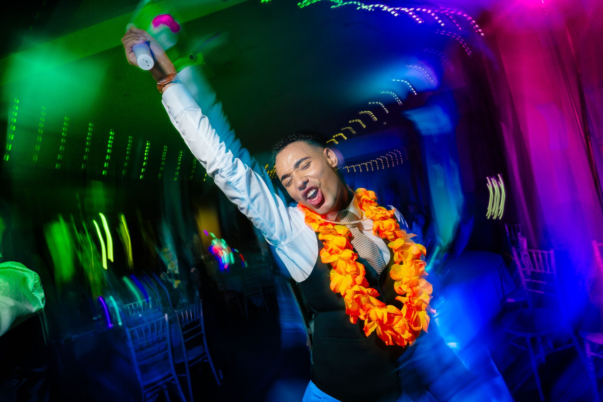 Colorful disco lighting effects in green, blue and pink create an energetic party atmosphere. Ellingham Hall