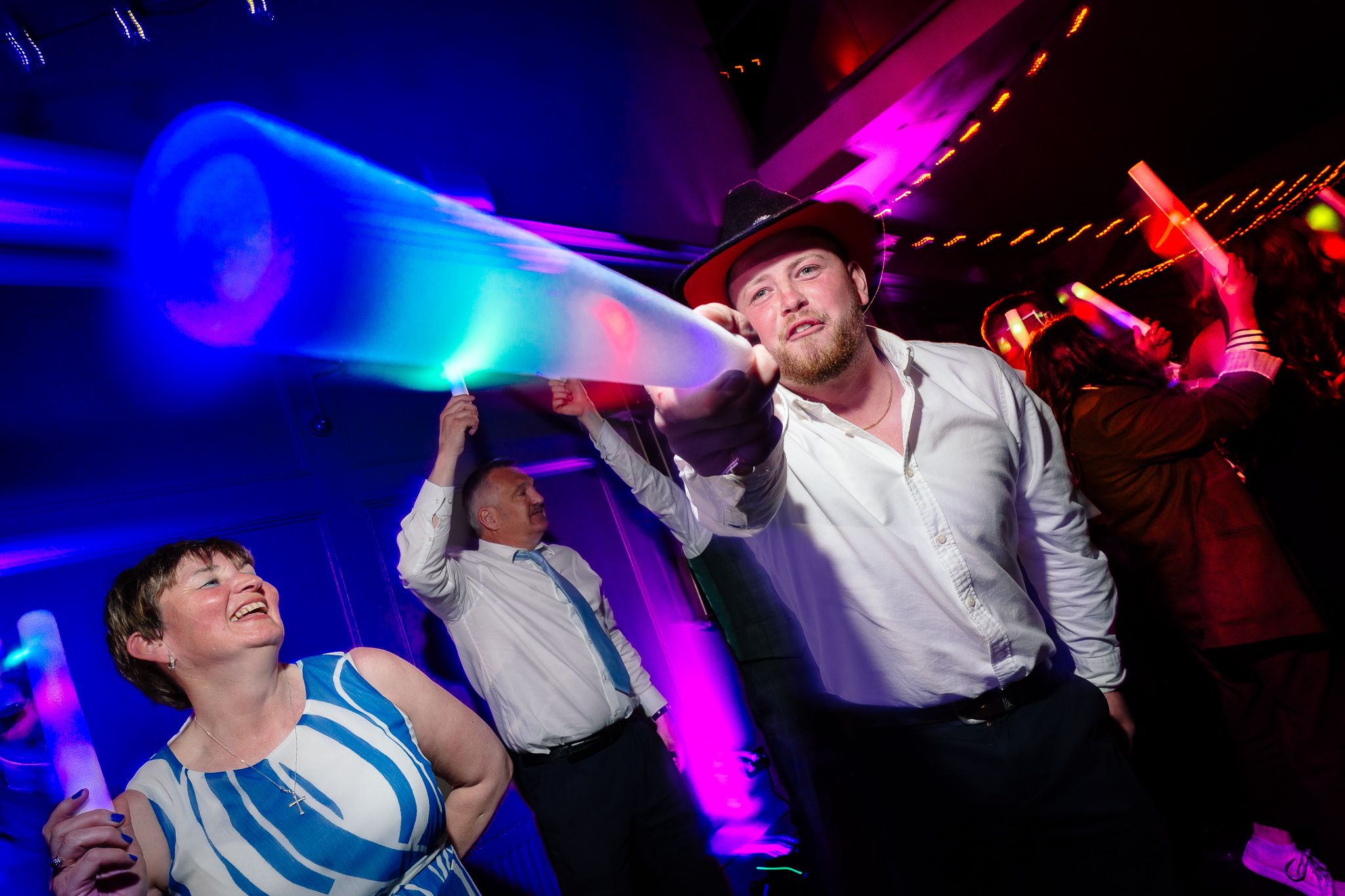 Dynamic dance party scene with blue and pink lighting effects creating an energetic atmosphere. Ellingham Hall