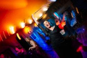 Dynamic dance floor scene with orange and blue lighting effects creating motion blur. Ellingham Hall