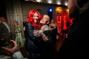 Wedding celebration captured with dramatic red lighting and motion effects. Ellingham Hall